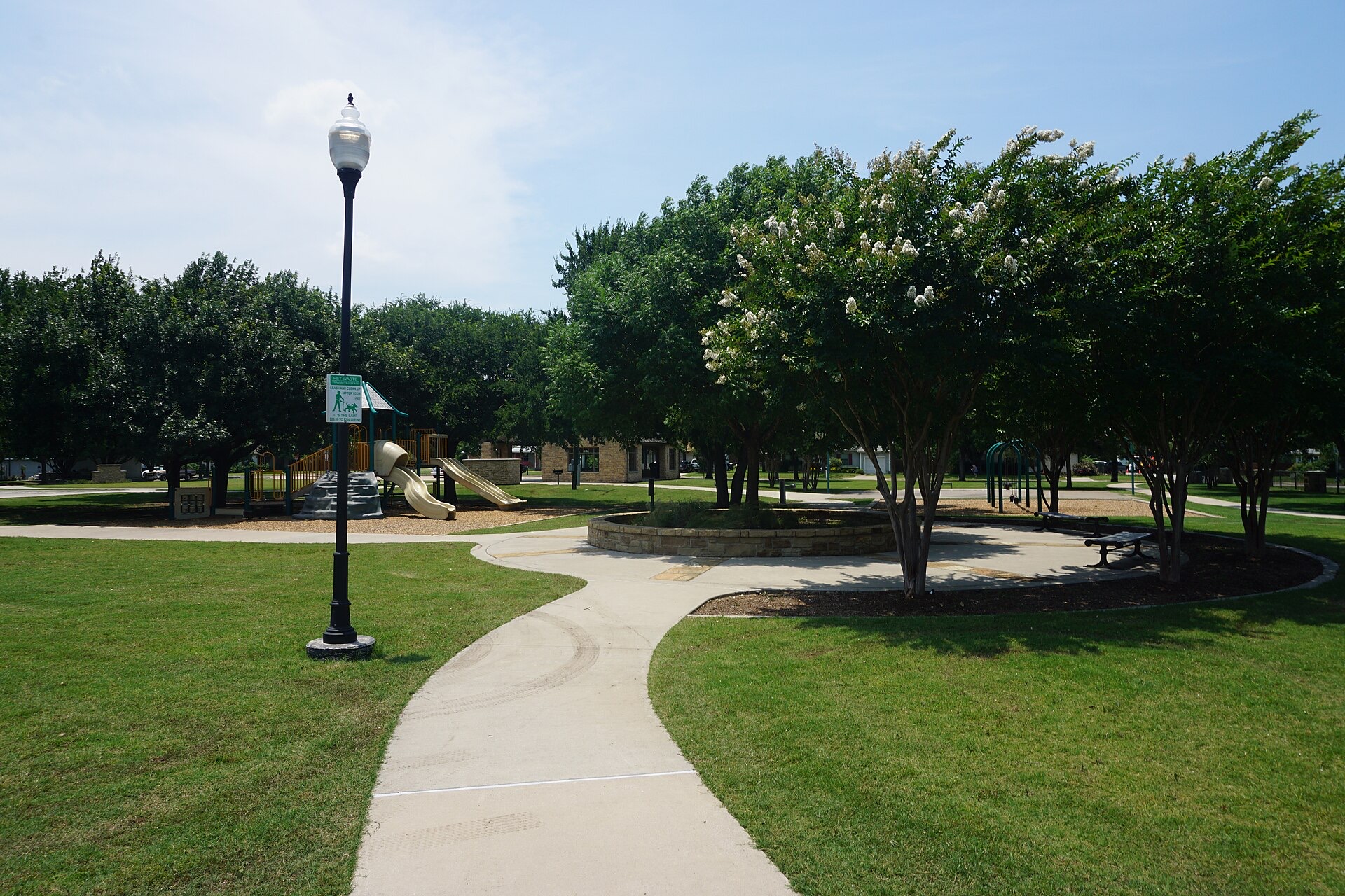 A playground and walking path at Youth Center Park in Frisco, Texas